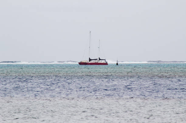 Moorea, French Polynesia - May 18, 2024: Catamaran Sailboat Anchored Inside Of Breakers On Reef