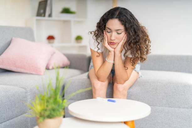 istock Patient woman on the sofa looking at a pregnancy test 2169799179