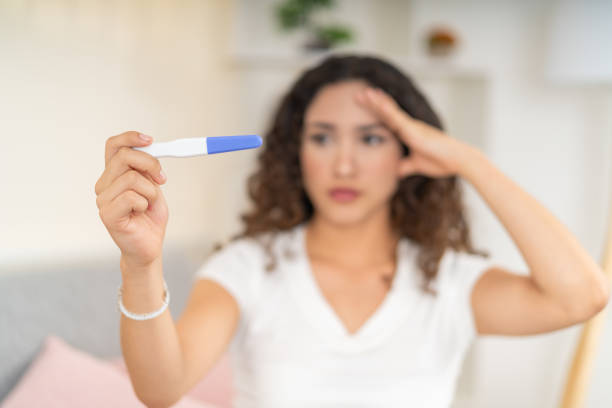 istock Pregnancy test held by a worried woman 2169799475