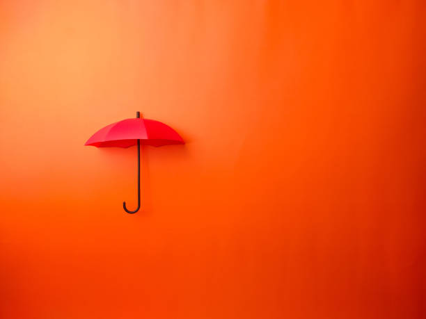 istock Top view red umbrella on a orange background 2169800794