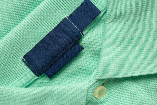 istock Blank blue laundry care clothes label on green shirt fabric texture background 2169801867