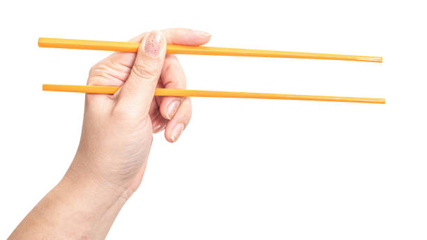 istock Female hand holding a orange plastic chopstick isolated on white background. 2169806198