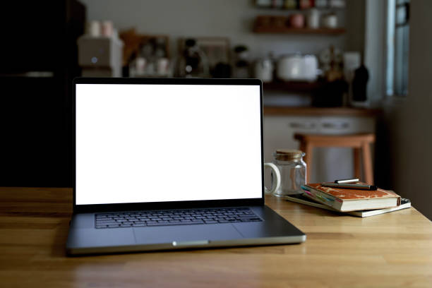 istock Mockup blank screen laptop computer on wooden table in kitchen room. 2169812514