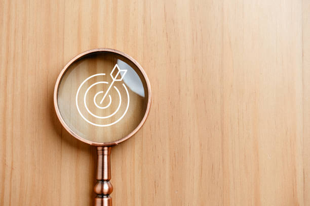achieve, bullseye, goal, purpose, management, marketing, objective, opportunity, performance, planning. A magnifying glass with a white arrow pointing to a target. Concept of aiming for a goal.