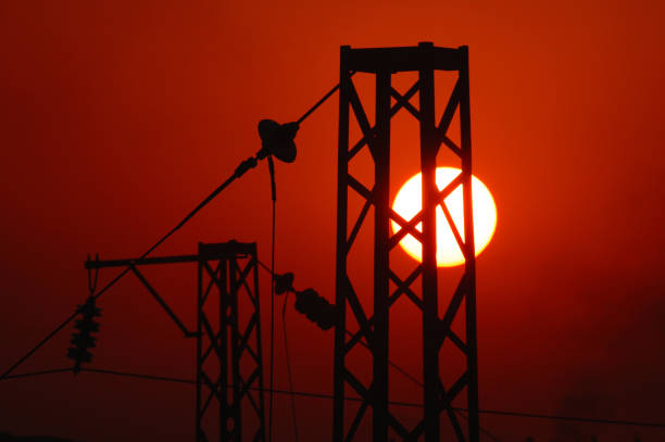 The setting sun shines on the electric wire tower