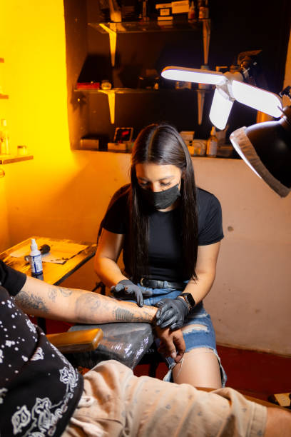 istock Woman tattooing man in her studio 2169821782