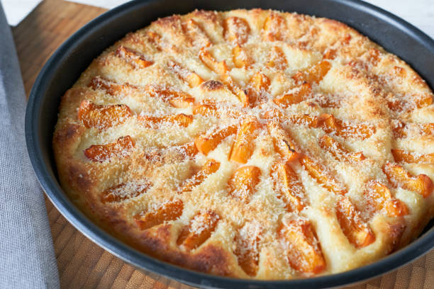 istock Apricot cake in a baking dish on a wooden table. 2169821846