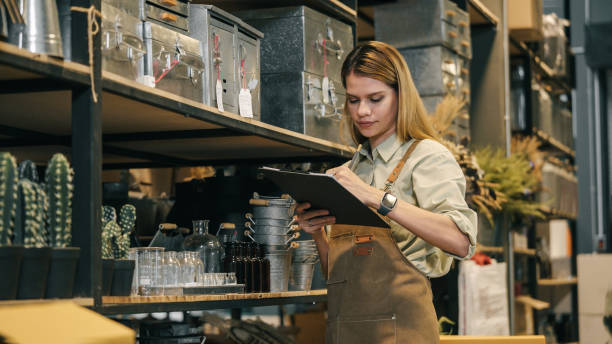 istock A small business warehouse  worker owner wearing apron checking inventory count stocktaking product on shelf warehouse storage room 2169825088