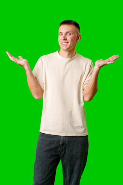 istock Young Man With Neutral Expression Shrugging His Shoulders Against Bright Green Background 2169825694