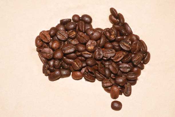 View of empty white coffee cup with roasted beans over rustic wood table at home in the kitchen