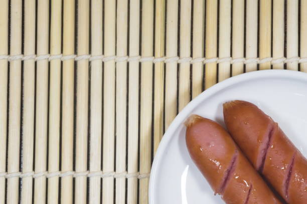 A tray of glistening grilled sausages served at a buffet close up