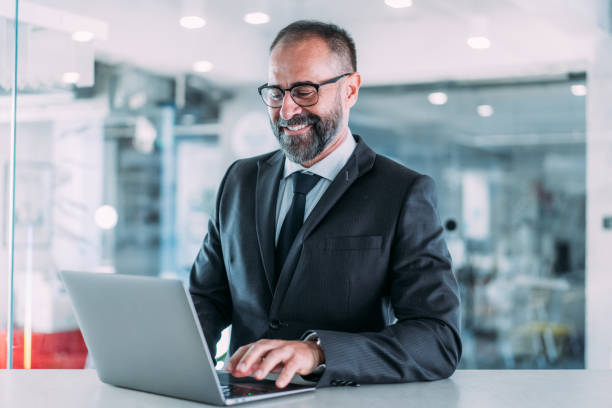 istock Successful businessman in modern office working on laptop. 2169837255