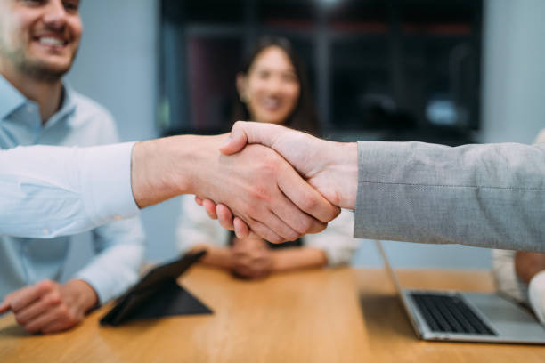 istock Businessmen shaking hands across the table. 2169837695