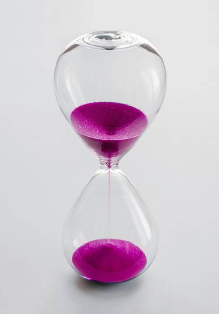 Hourglass containing pink sand isolated on white background. Concept of time passing