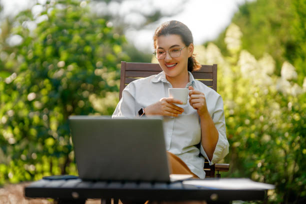 istock woman working on laptop in summer morning 2169839355