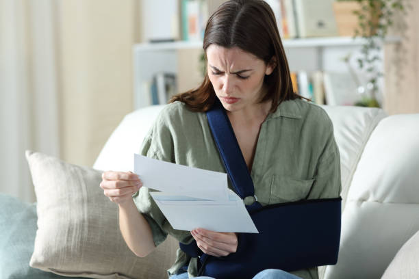 Convalescent worried woman reading document at home stock photo