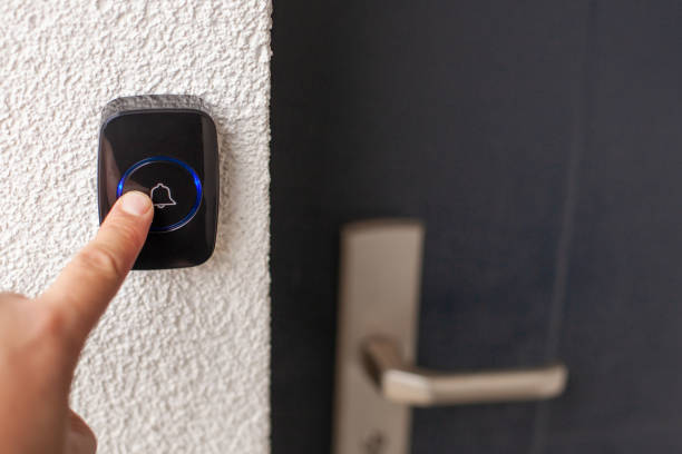 istock Pressing Black Doorbell with Blue Ring on White Wall 2169844857