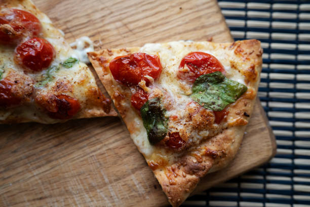 Spinach and cheese pizza, cut in half, Italian food, on a wooden table.