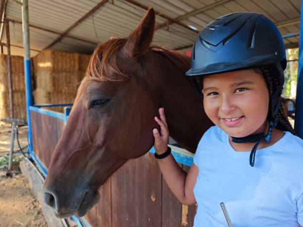 Boy horseback riding, performing exercises on horseback, horse theraphy against anxiety