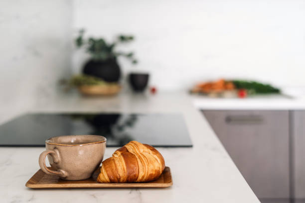 istock Croissant and coffee cup at white marble countertop in kitchen 2169849661