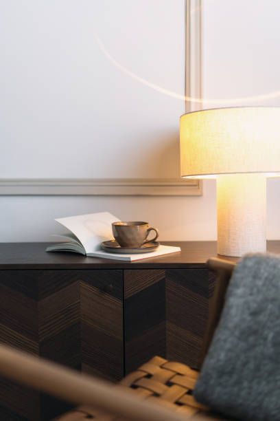 istock Open book, reading lamp and coffee cup on design wooden commode 2169849697