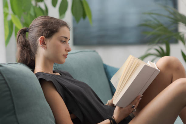 istock Relaxed adolescent girl reading a book at home 2169850071
