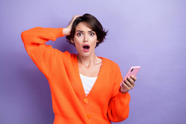 istock Photo of impressed shocked lady dressed orange cardigan getting sms modern device empty space isolated purple color background 2169858207