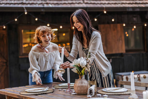 Friends Setting a Cozy Outdoor Dinner Table
