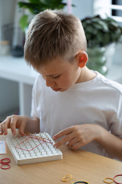 istock A Child Actively Engaged in a Fun Creative Rubber Band Art Activity Within His Home Environment 2169859115