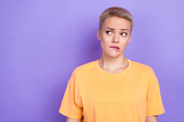 istock Photo of young bad mood woman bite lips nervous look empty space oops problem failed forgot deadline time isolated on violet color background 2169862632
