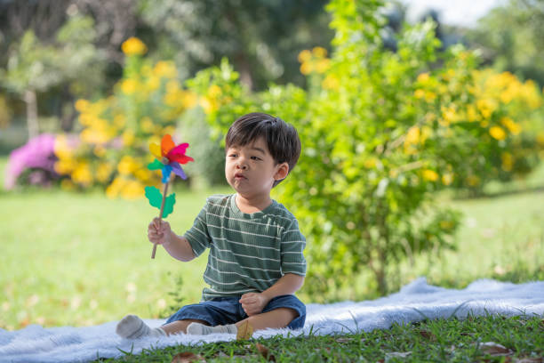 istock Asian little child having fun playing with windmill in the park 2169863582