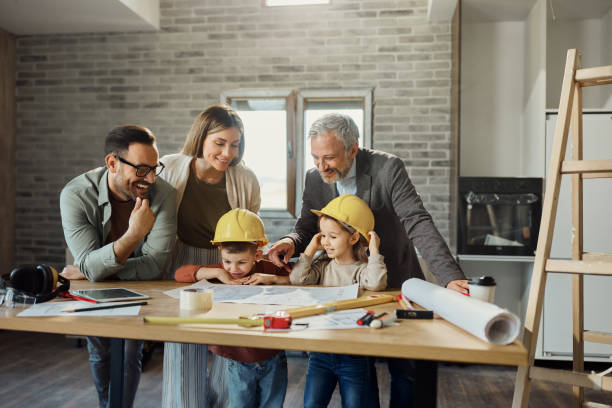 istock Happy family and their architect reading blueprints during home renovation process. 2169863797