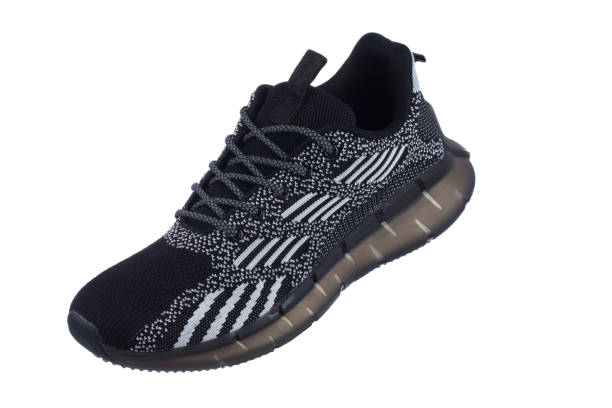 istock Black sneakers with white fabric stripes close-up on a white background. 2169863873
