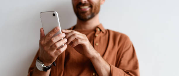 istock Partial view of blurred man using mobile phone near wall, banner crop 2169864600