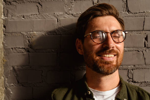 istock Positive interior designer in eyeglasses standing near brick wall 2169864870