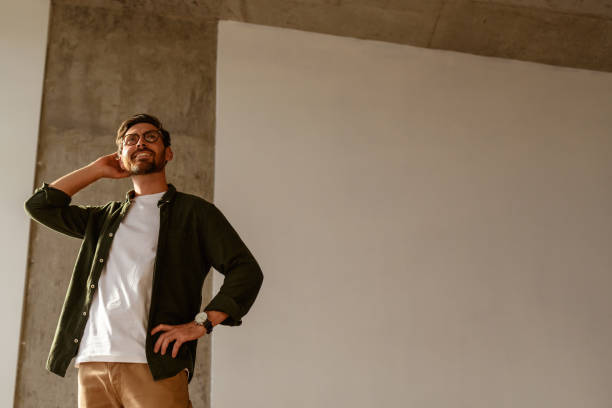 istock Low angle view of joyful interior designer looking away in apartment 2169864916