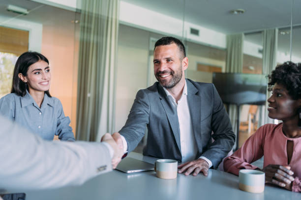 istock Businessmen shaking hands across the table. 2169865813