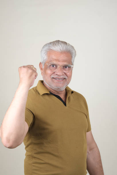 Confident Mature Man Smiling Against Off-White Background - Portrait