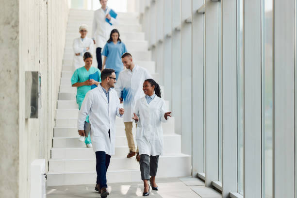 Happy doctors talking while walking through hallway of a hospital.