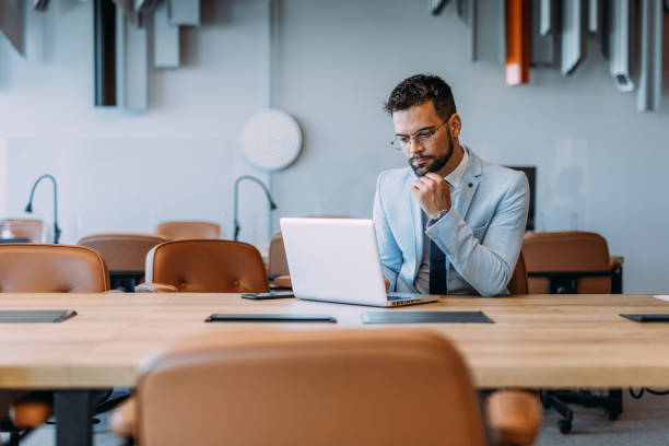 istock Successful businessman in modern office working on laptop. 2169869959