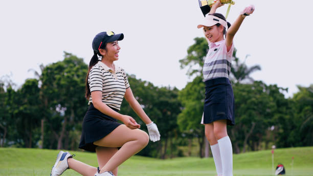 Girl raising a golf trophy in excitement