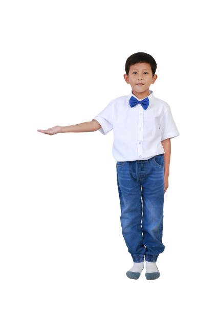 Smiling Asian little boy child in nice looking outfit standing presenting something on empty space, isolated on white studio background. Image full length with clipping path.