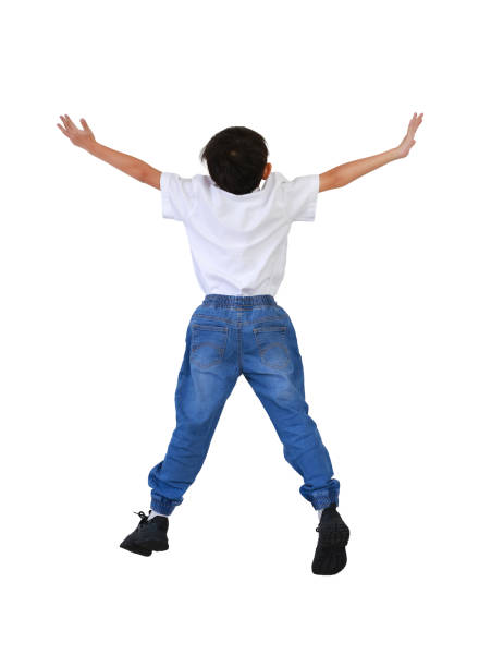 Young boy jumping in the air on neutral background. Studio shoot