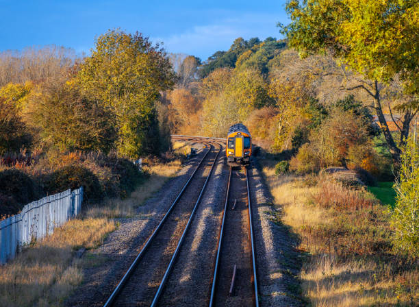 Rural railway station Autumn Midlands UK Passenger commuter train arriving at rural country station with autumn colour surrounding it.