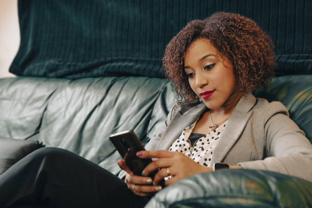 istock Young businesswoman using smartphone on leather sofa 2169877304