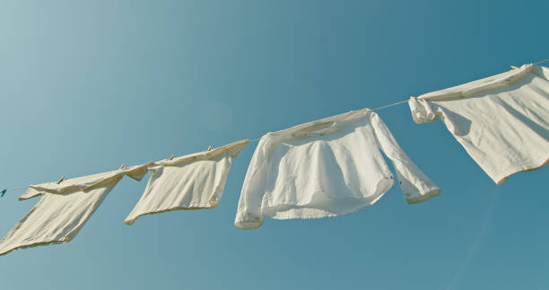istock Freshly washed white clothes drying on a clothesline against a clear blue sky. 2169880310