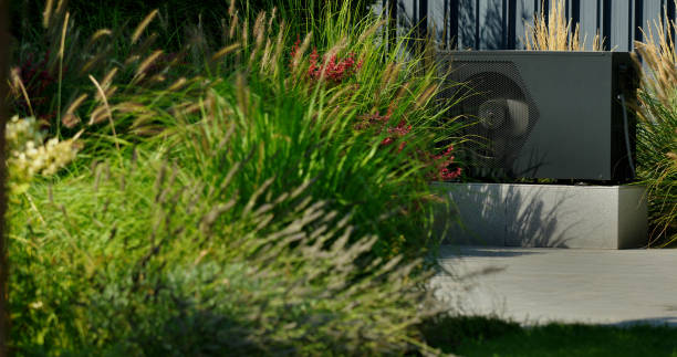 istock Modern heat pump unit installed by a backyard pool, surrounded by vibrant greenery and blooming plants. 2169880849