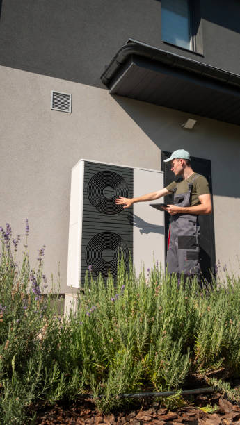 istock Technician adjusting a heat pump unit outside a house on a sunny day. 2169882641