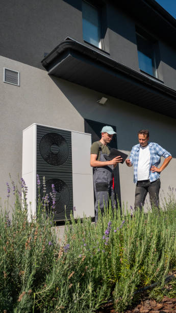 istock Homeowner and technician review heat pump settings outside. 2169882943