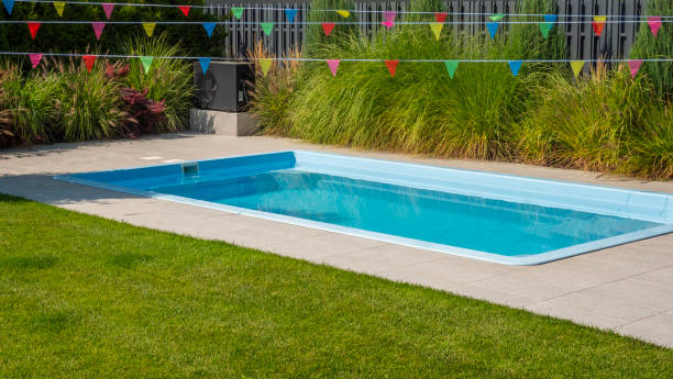 istock Sparkling backyard pool surrounded by greenery and festive flags. 2169883315
